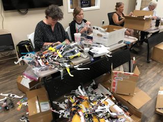 Volunteers with Astronomers Without Borders examine and package lightly used solar eclipse glasses for redistribution.