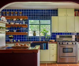 Kitchen with blue tiles and yellow green cabinets
