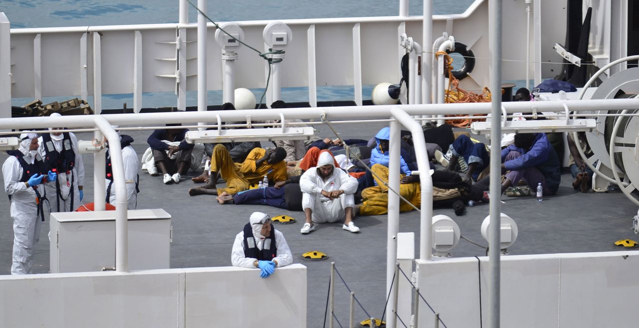 Survivors of the smuggler&amp;#039;s boat that overturned off the coasts of Libya lie on the deck of the Italian Coast Guard ship Bruno Gregoretti.