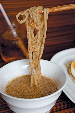White bowl, noodle dish, chopsticks, dark wood surface