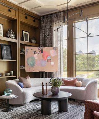 living room with curved white sofa and built ins with paneled ceiling