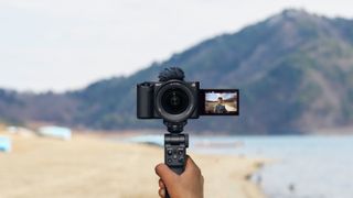 Sony ZV-E1 full-frame vlog camera held up to film at beach