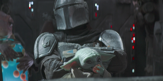 the mandalorian baby yoda held by mando and eating frog lady's egg