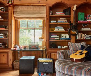 music room with guitar, striped loveseat and Marshall amp