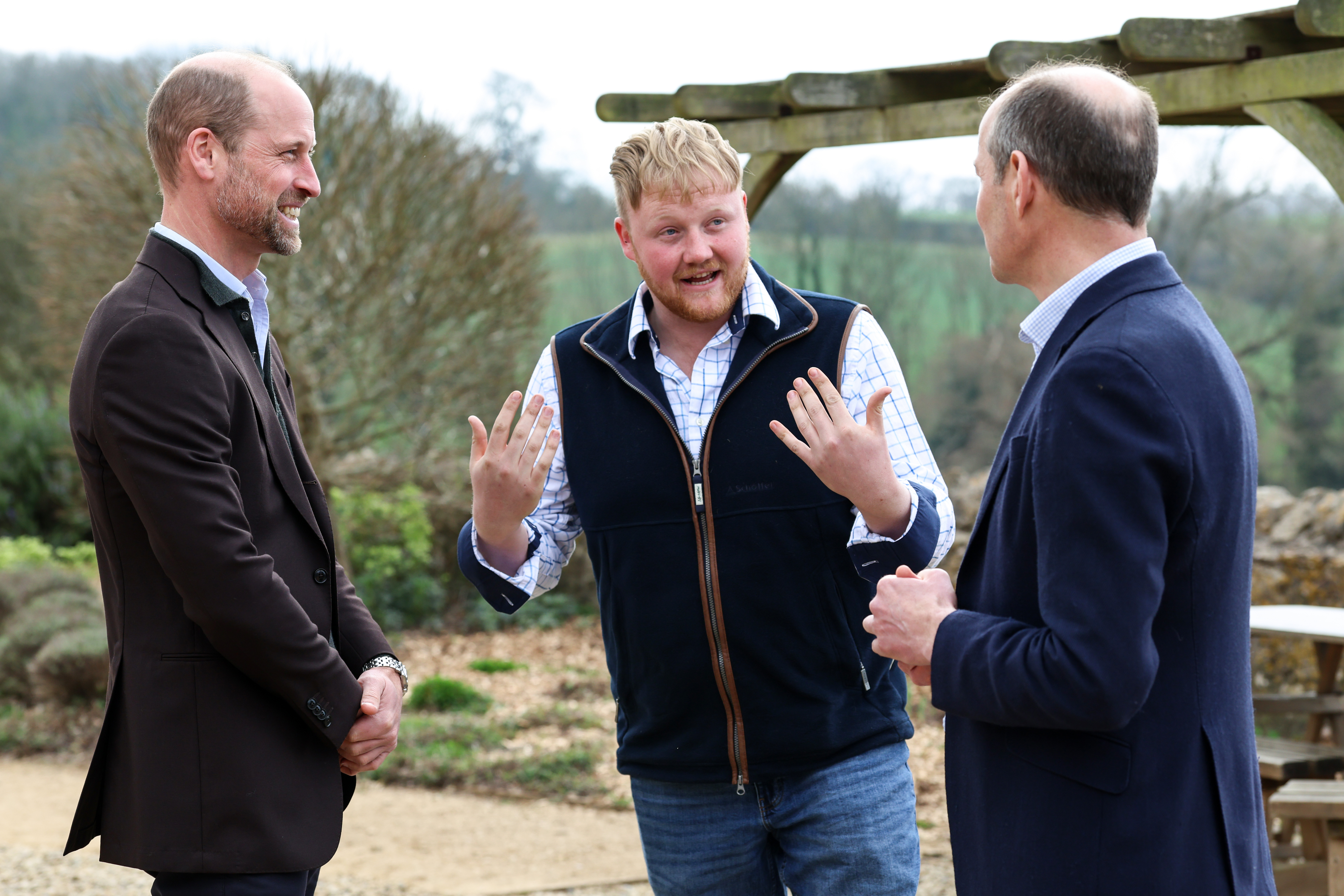 Prince William, Prince of Wales speaks with Clarkson's Farm stars Kaleb Cooper and Charlie Ireland during an event for sixty of the Duchy of Cornwall's next generation of farming tenants, on March 26, 2025 in Pensford, England