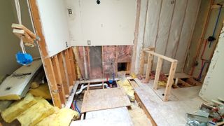 Building work being carried out in a room with insulation on top of exposed floor joists