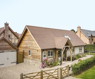 A timber frame home on a new housing development with a gravelled driveway