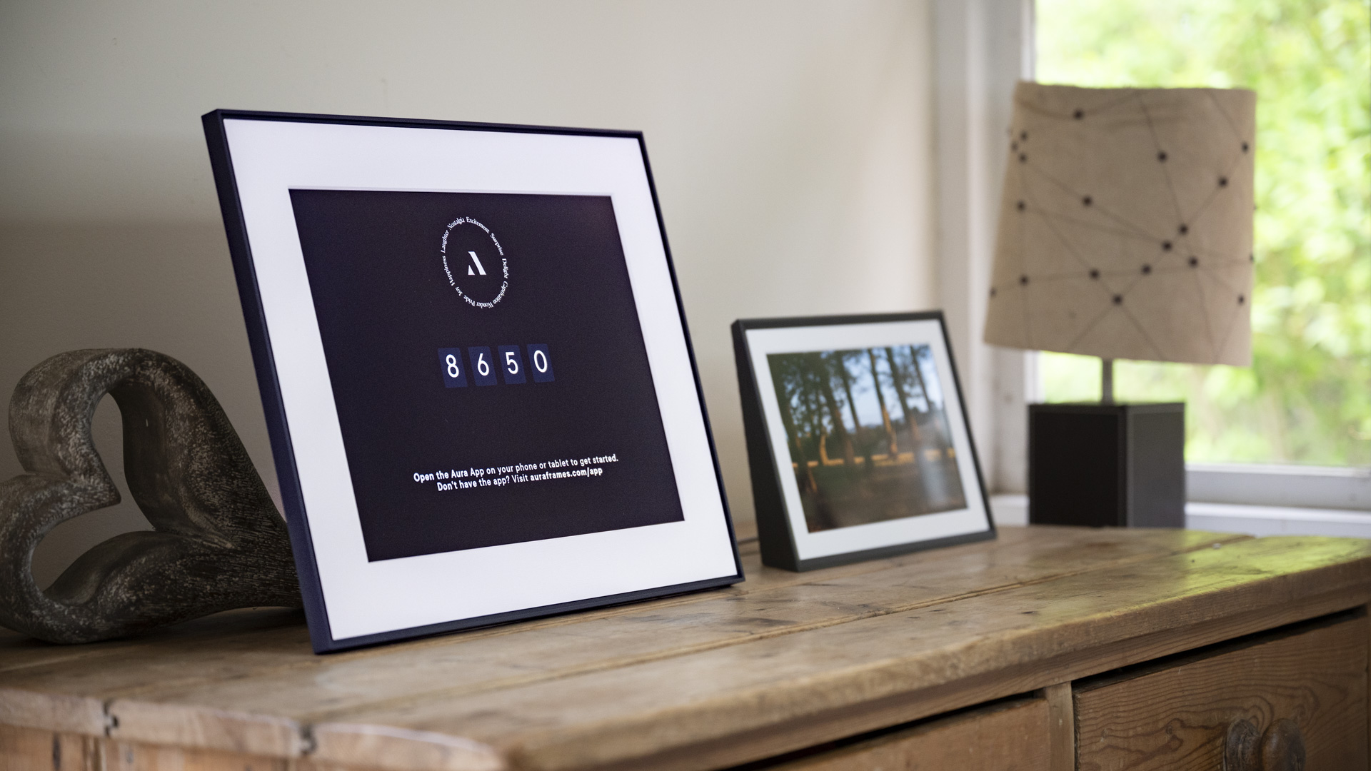 Aura Walden digital photo frame on a wooden sideboard alongside the smaller Aura Carver Mat