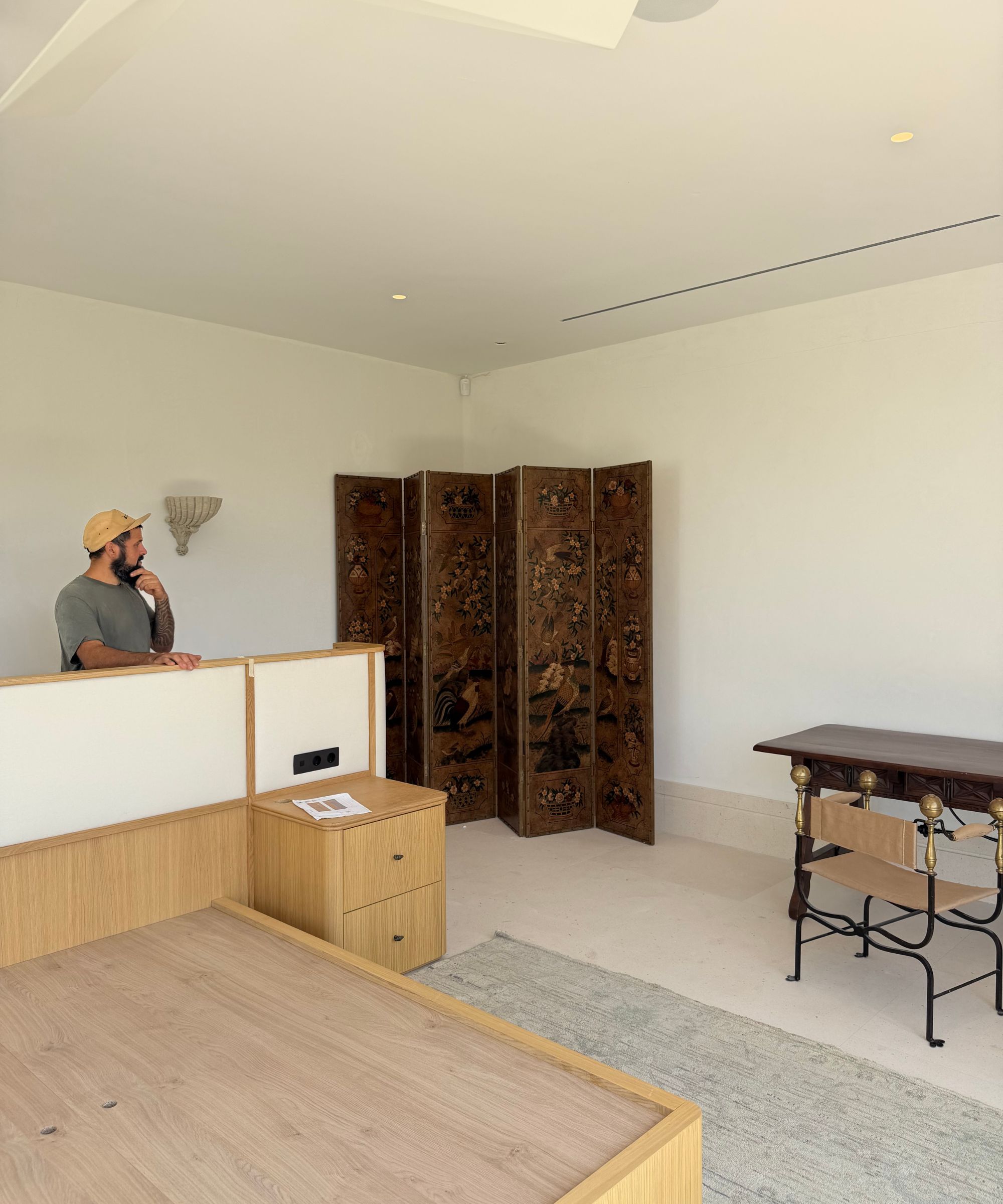 Near-empty room with boxes and table, large folding screen in back corner