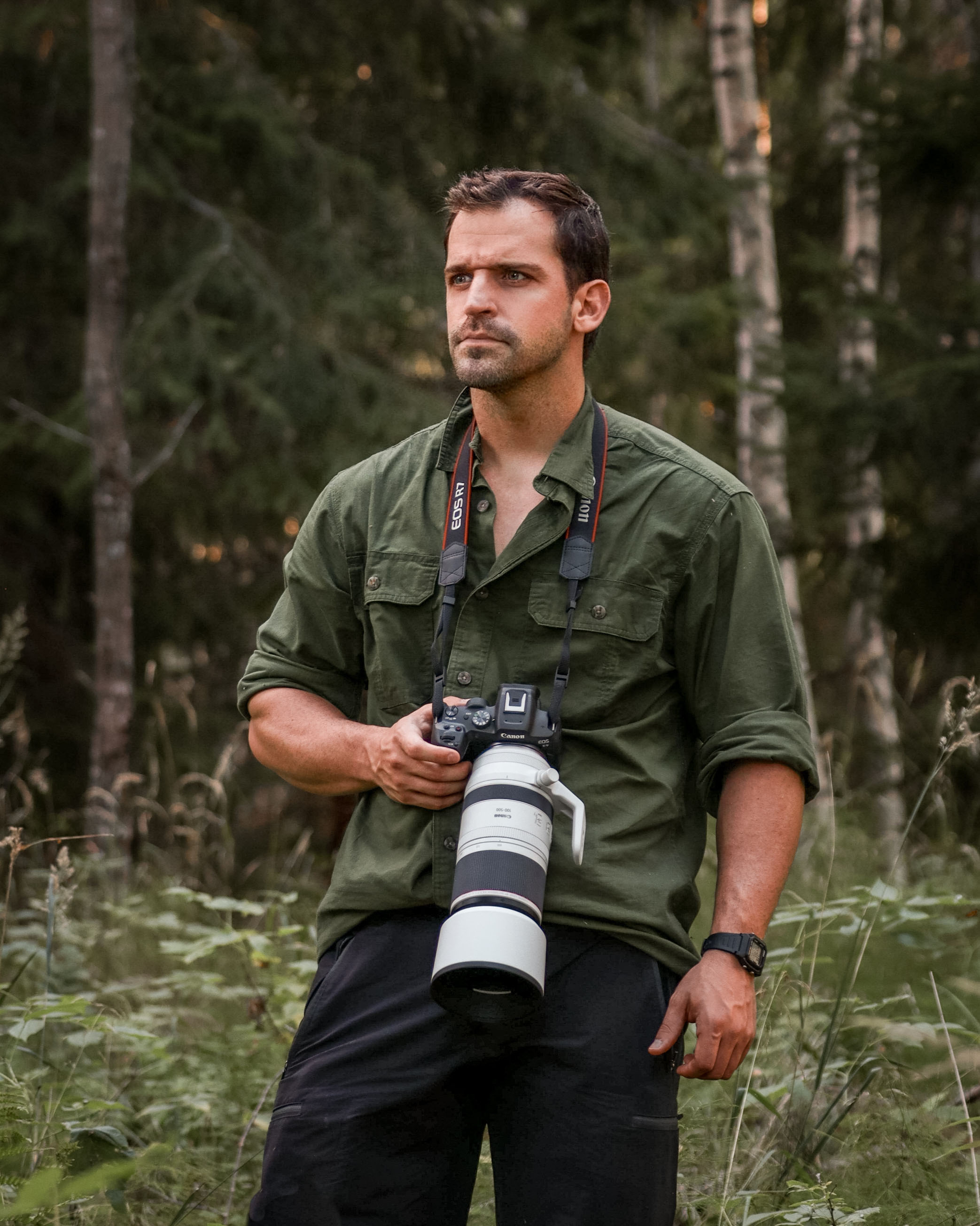 A profile shot of photographer Esteban Frey holding a camera against a green background
