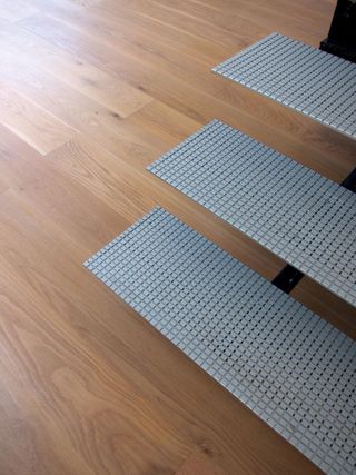 Engineered ply floorboards laminated with oak veneer, and Alcan aluminium steps leading to the studio.