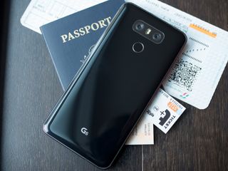 LG G6 on top of a passport and plane tickets