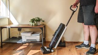 A person holding the Tineco Floor One S5 Pro hard floor cleaner
