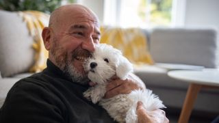 Man hugging his Maltese dog