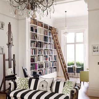 living room with attached library room and ceiling height sliding ladder