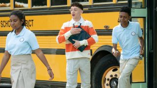 Jacob walking of the bus clutching a bunch of folders in the "Smith Playground" episode of Abbott Elementary.