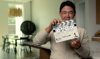 Tom Kim holds a clapper board during Netflix Full Swing filming