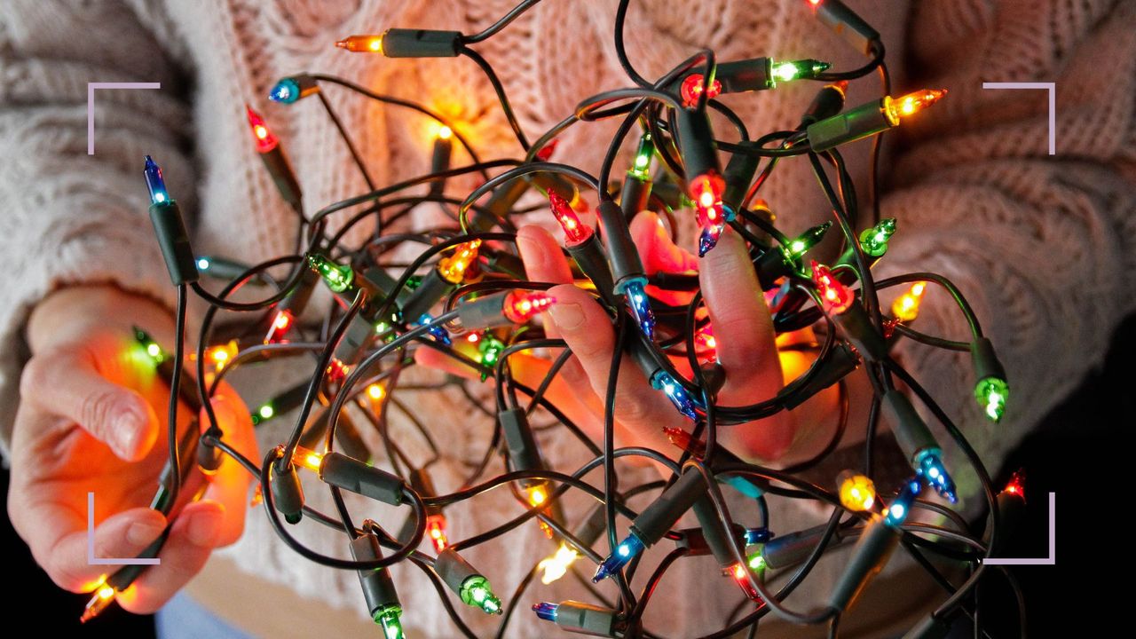 Hands holding a cluster of color fairy lights to question the best way to store Christmas lights