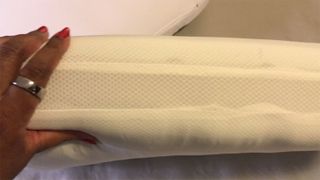 A hand squeezing a Casper Foam Pillow with Snow Technology