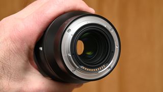 Nikon Z 35mm f/1.2 S product shot with lens held in hand