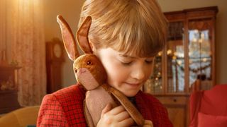 A boy cuddling a toy rabbit