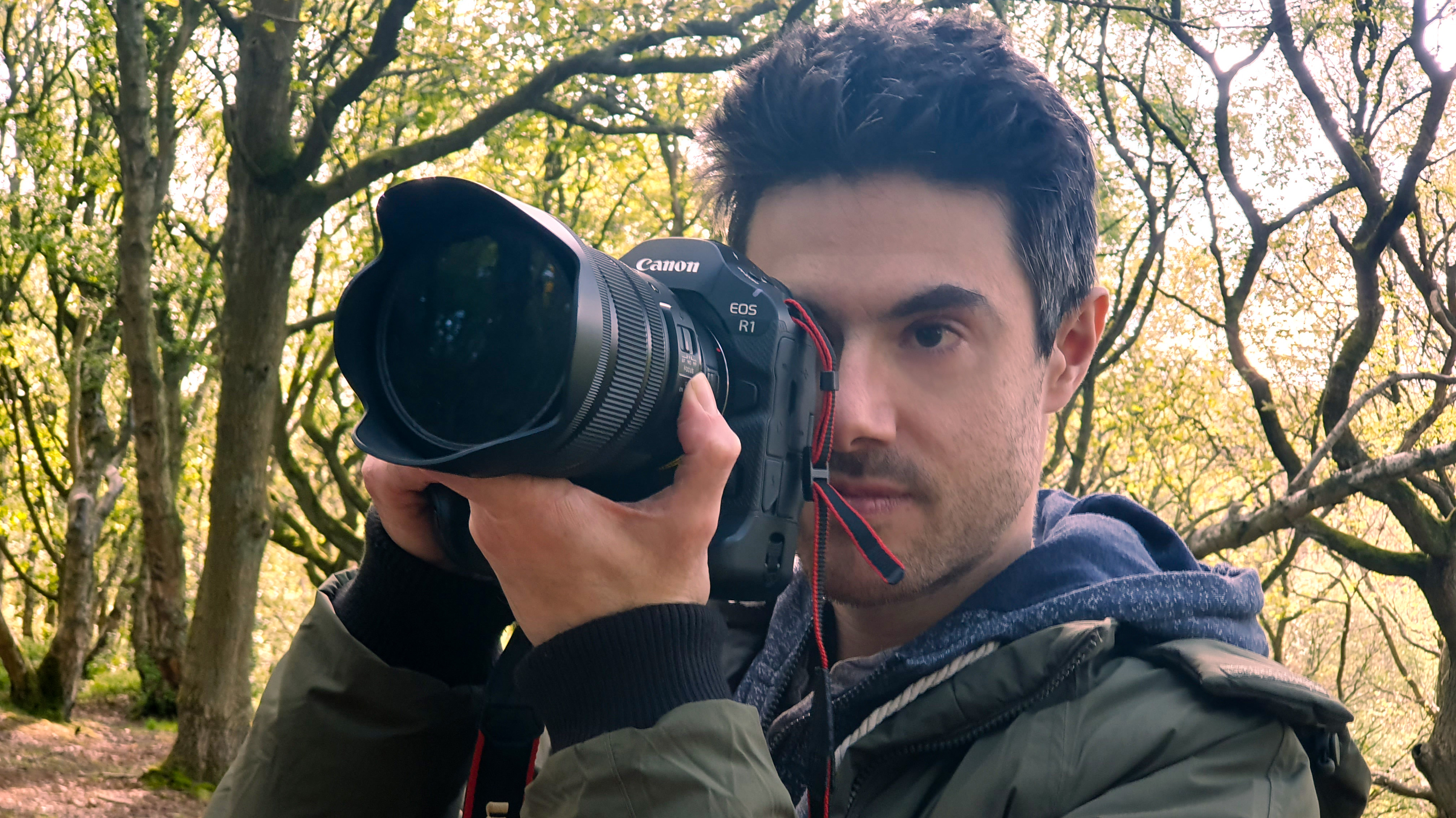 A man holding the Canon EOS R1 camera