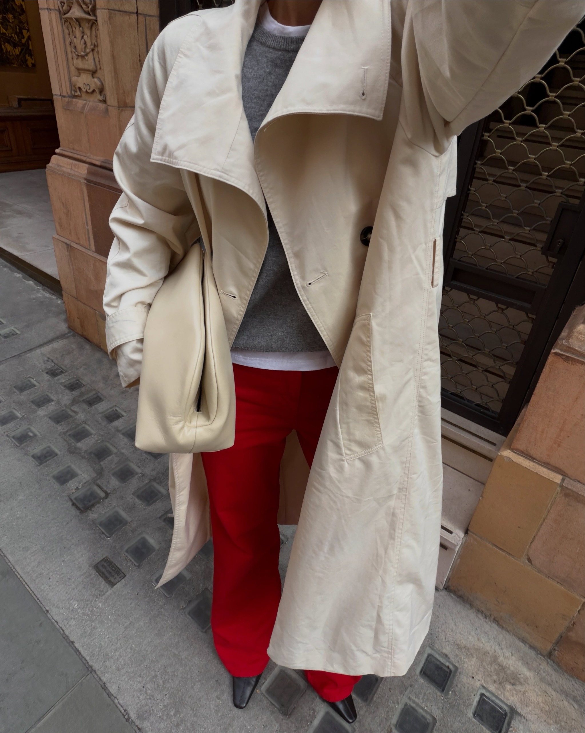 @thealiceedit wears red trousers with a beige trench coat and black boots