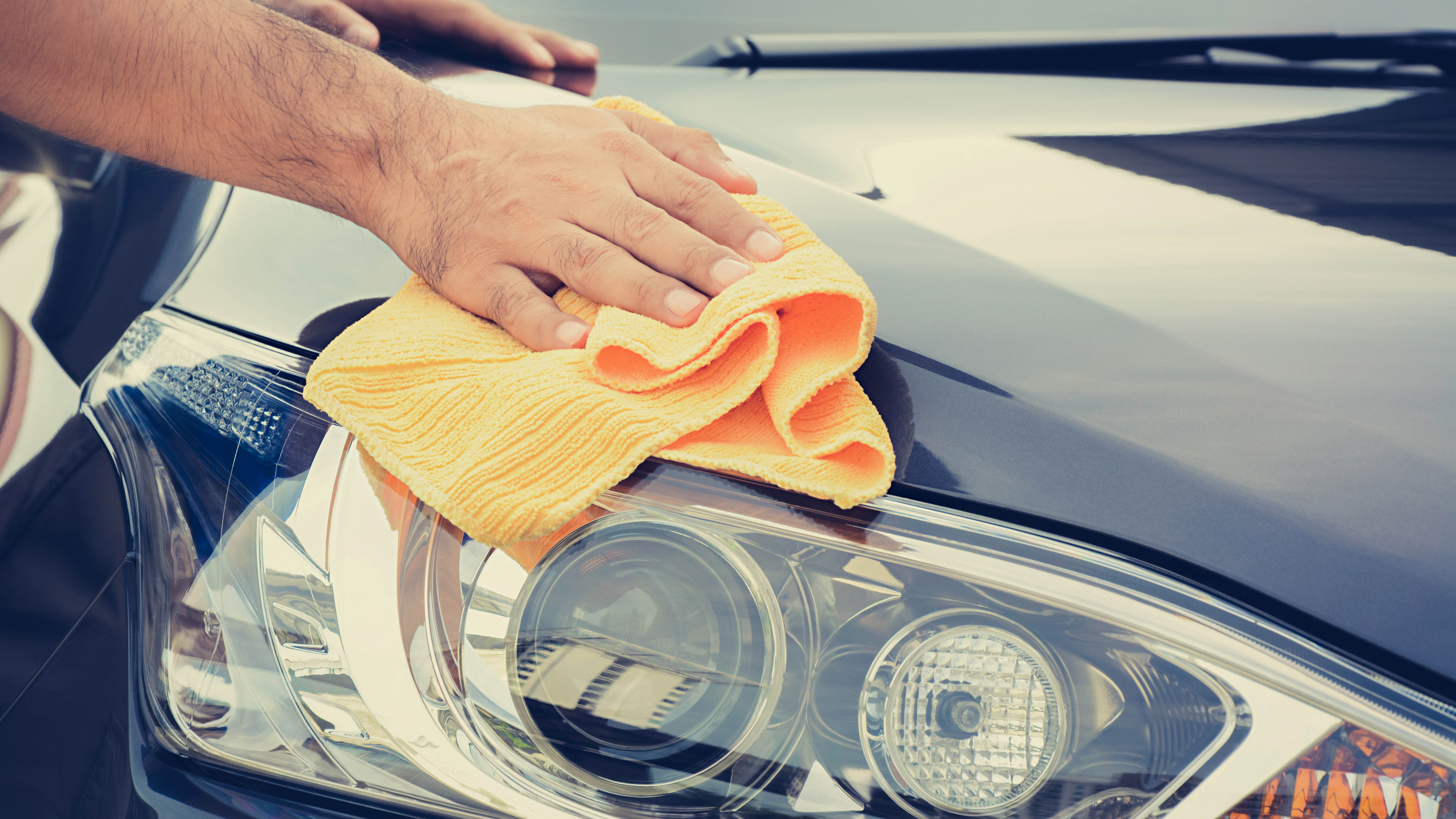 A microfiber cloth being used to clean a car