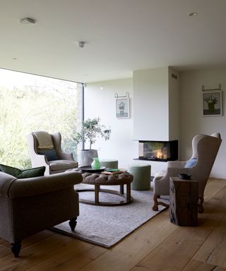 living room with large window, armchairs and fireplace
