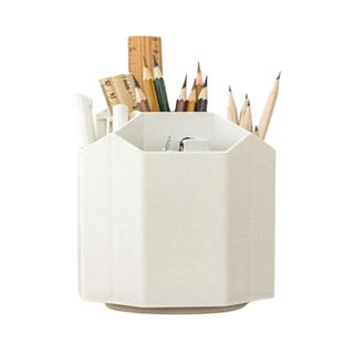 A white rotating desk organizer with stationery in it