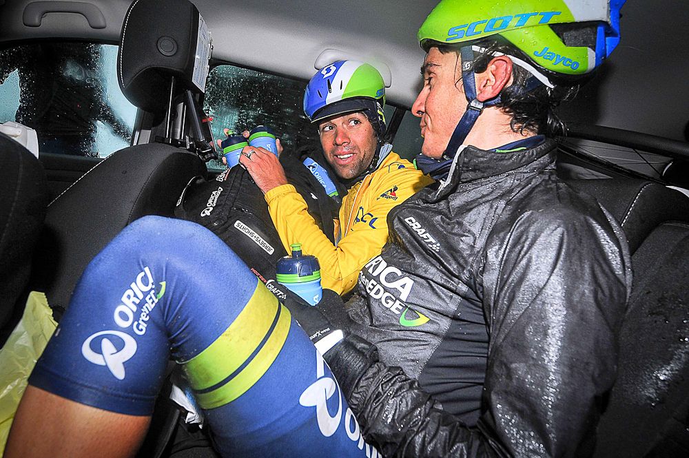 Race leader Michael Matthews and Amets Txurruka take cover in an Orica-Greenedge team car during stage 3 at Paris-Nice.