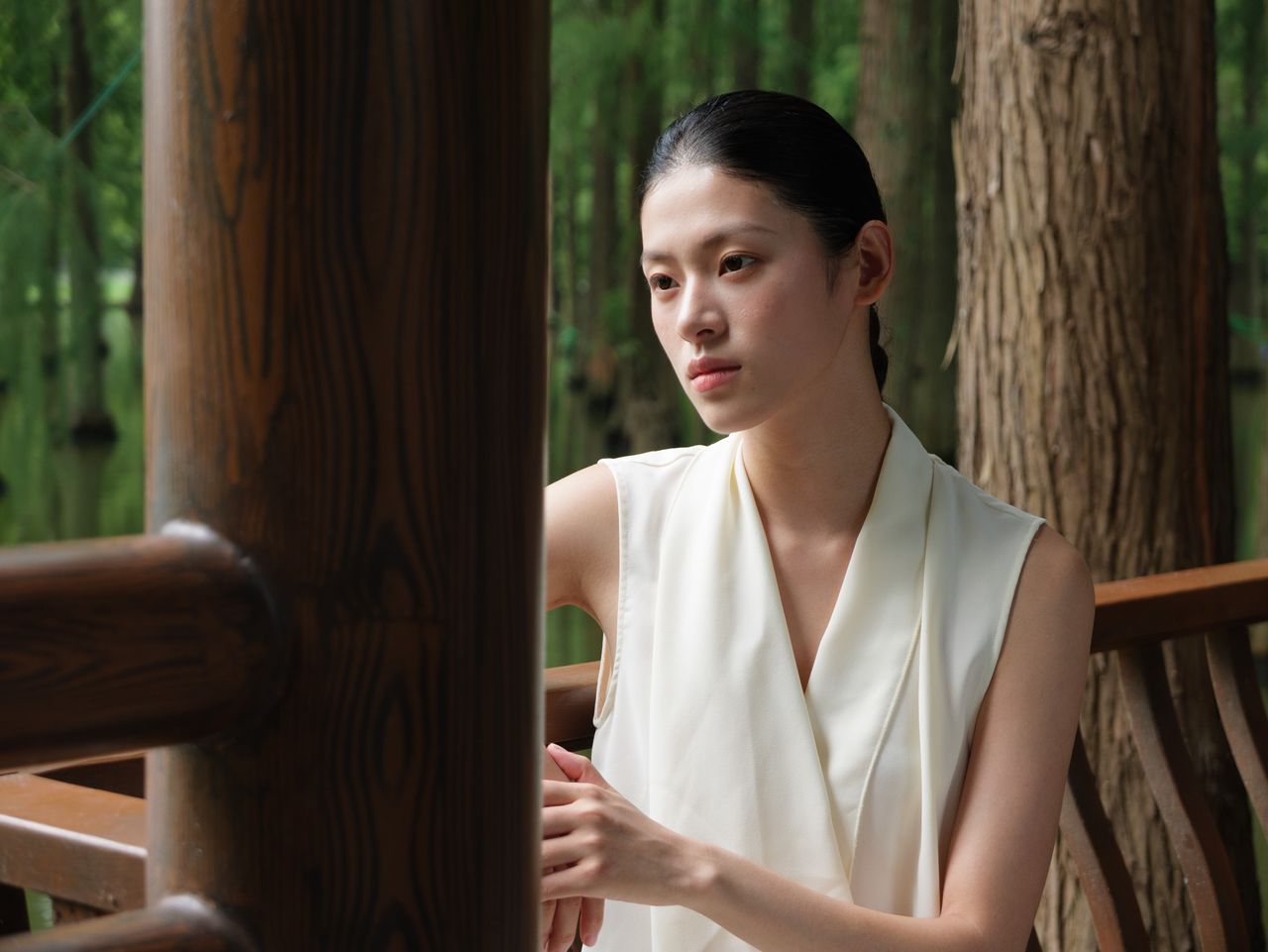 Panasonic Lumix L10 sample gallery: female model in white dress, leaning against a wooden barrier in a nature reserve
