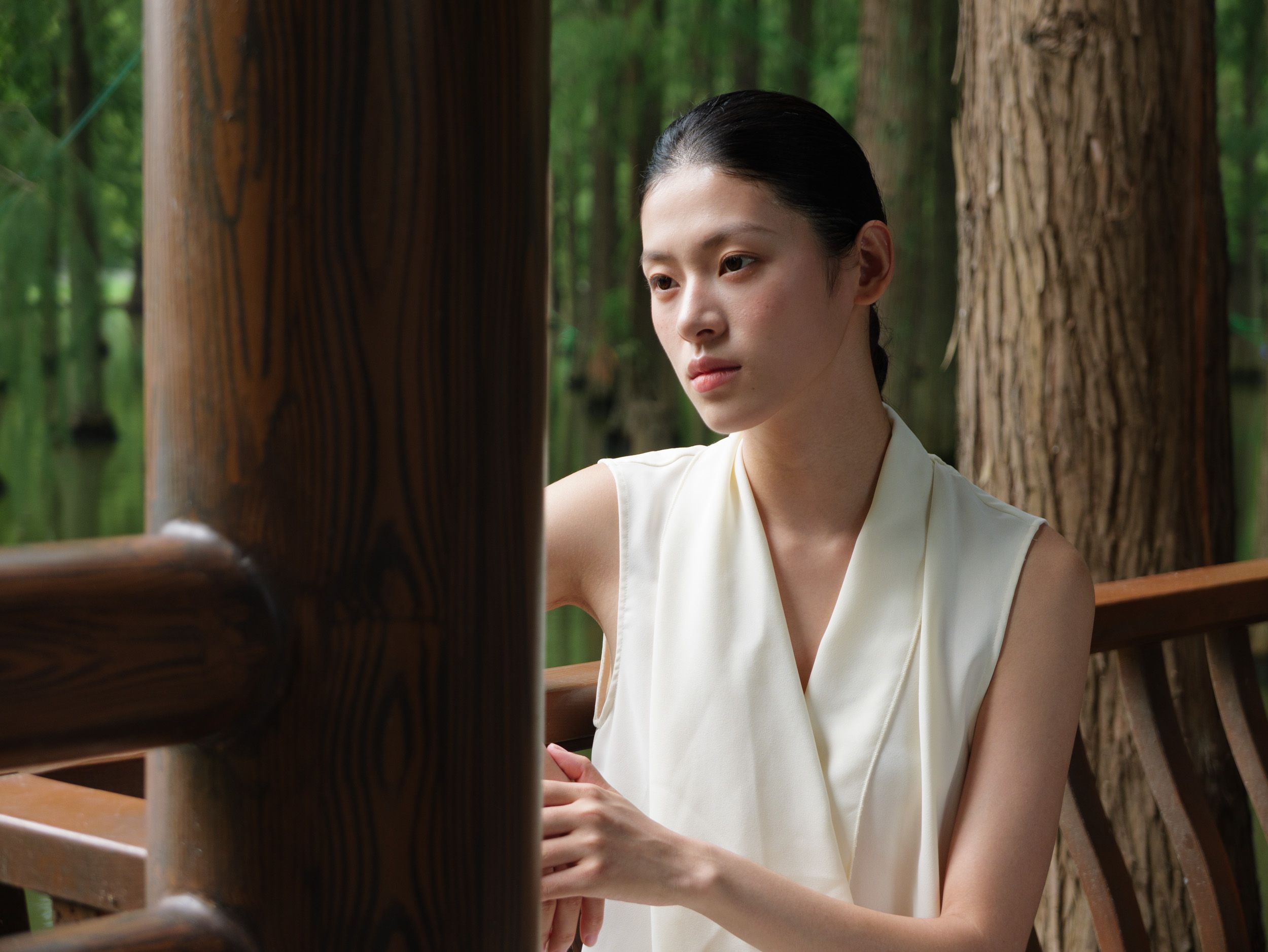 Panasonic Lumix L10 sample gallery: female model in white dress, leaning against a wooden barrier in a nature reserve