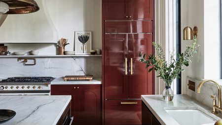 A kitchen with red cabinets painted in lacquer paint and white countertops