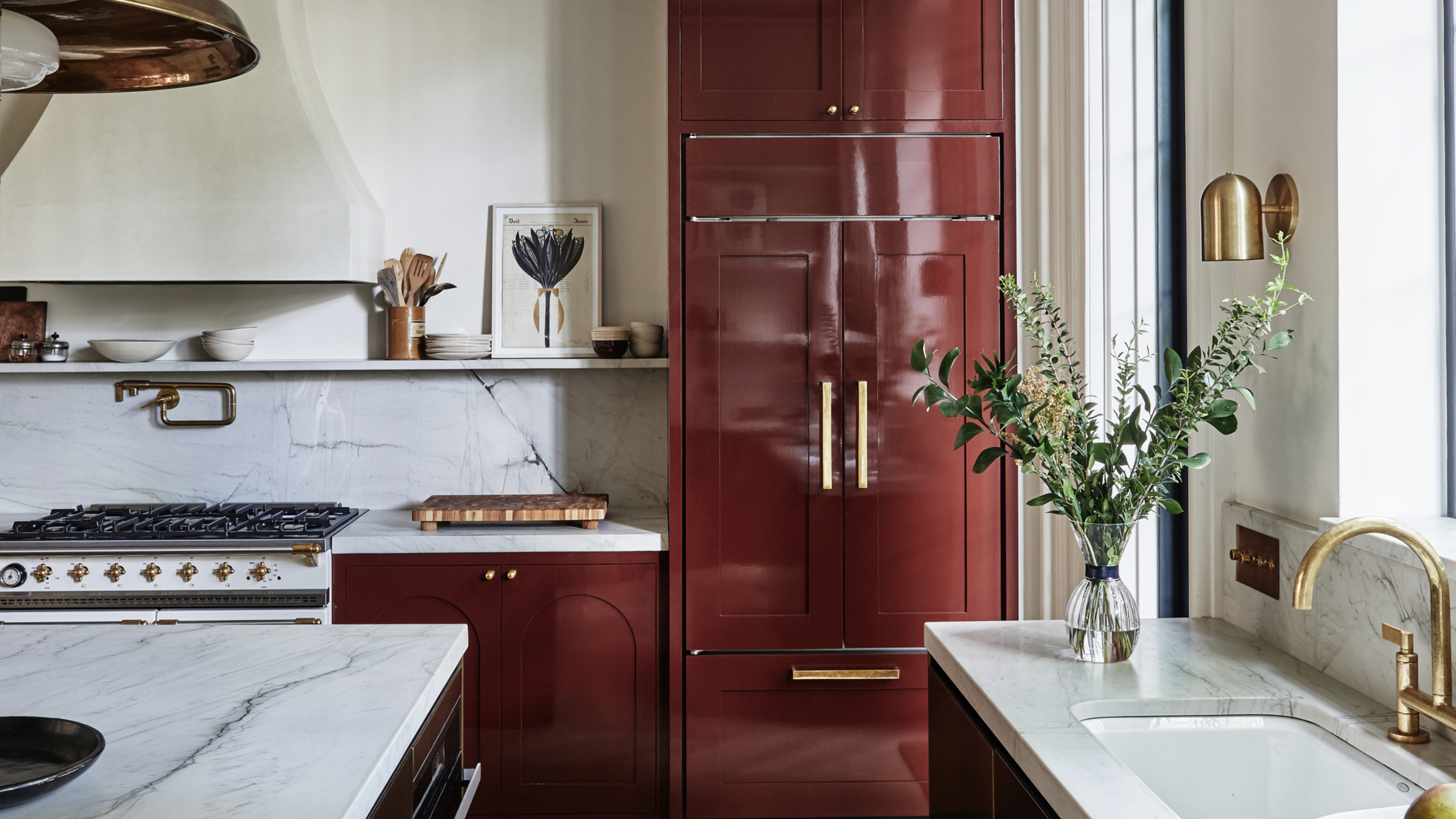 A kitchen with red cabinets painted in lacquer paint and white countertops