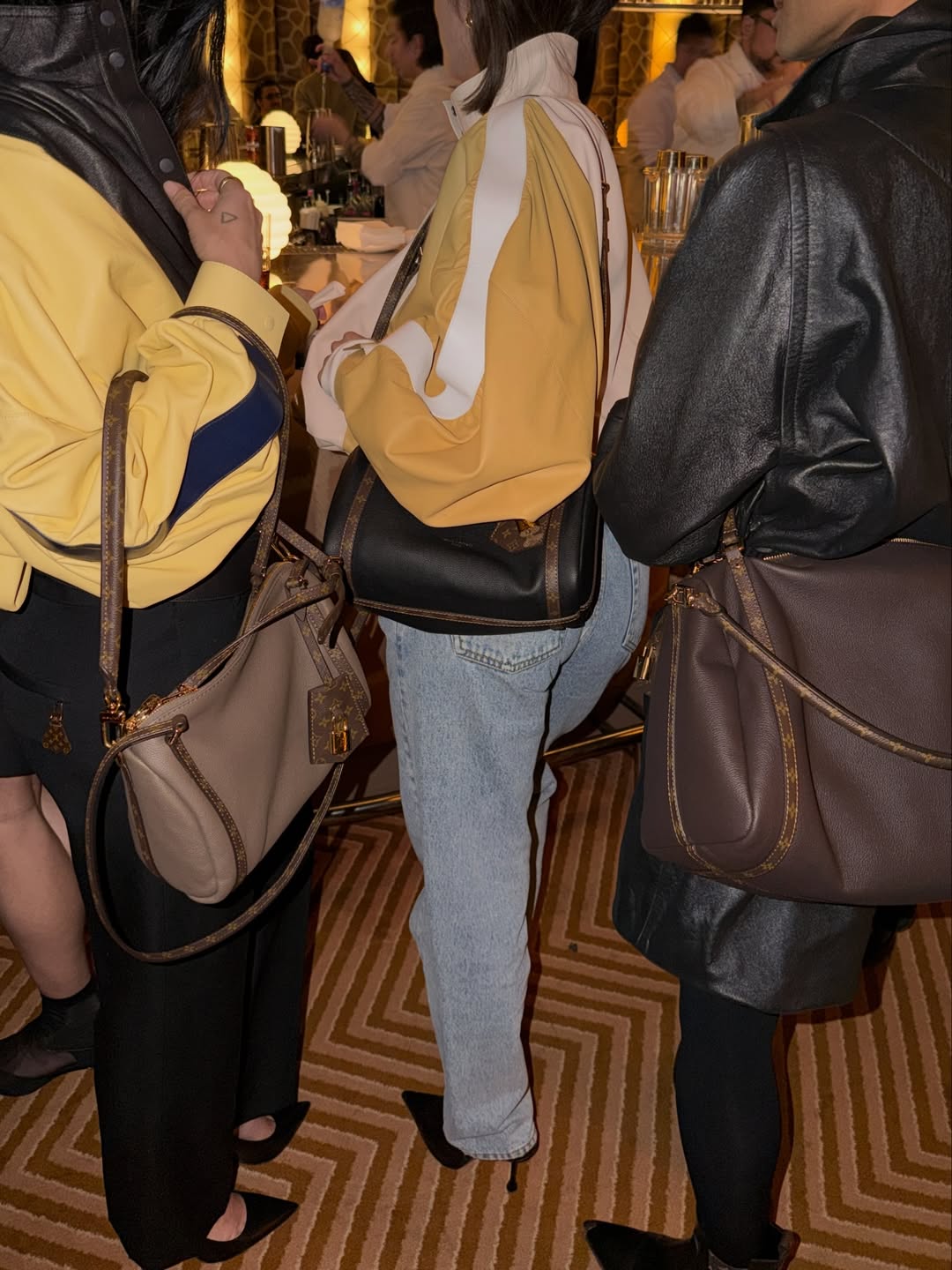 Aimee Song's Instagram post of three people holding Louis Vuitton bags.