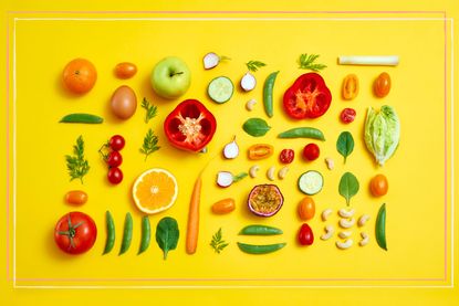A selection of fruit and vegetables on a yellow background to illustrate the 16:8 diet