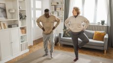 woman and man in a living room practicing balancing exercises 