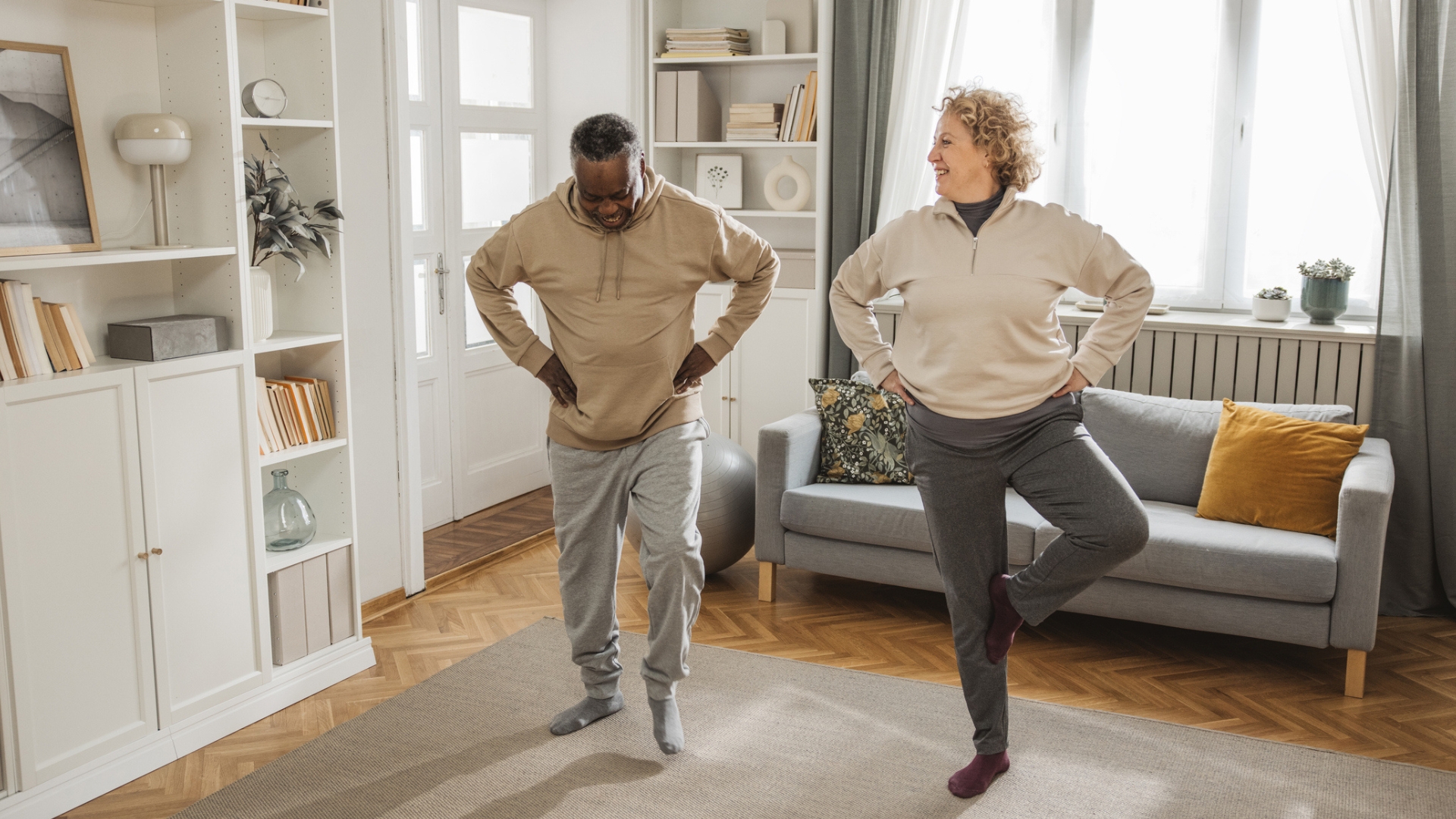 woman and man in a living room practicing balancing exercises 