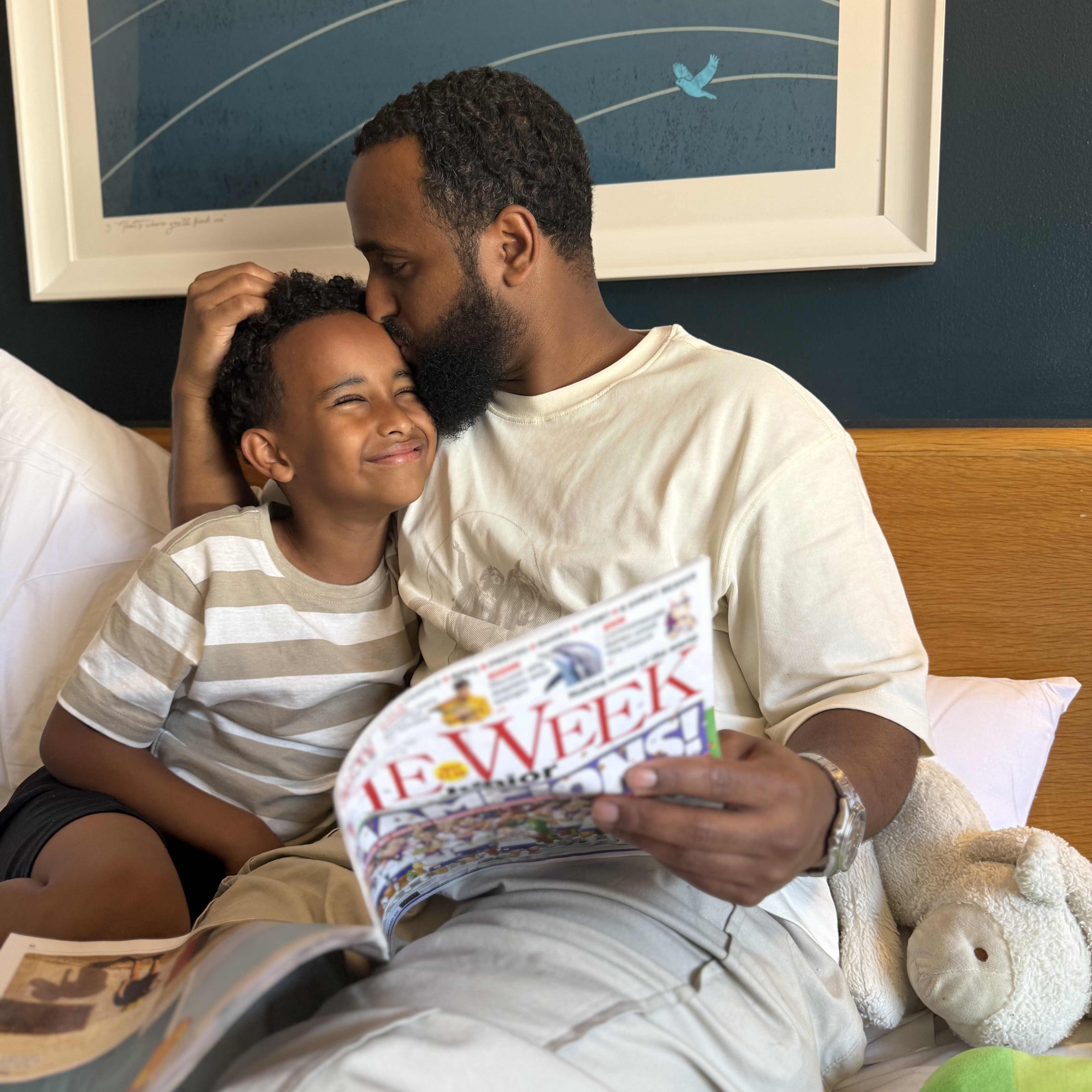 Abz reading The Week Junior with his son