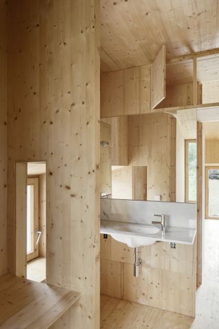 The bathroom is made out wood in House in a House by MAIO