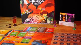 Box, tokens, cards, and board from The Captain is Dead: Dangerous Planet laid out on a wooden table, against a black background