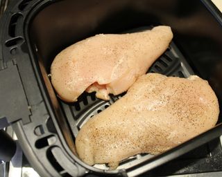 Two uncooked chicken breasts in Gourmia 4-quart digital air fryer