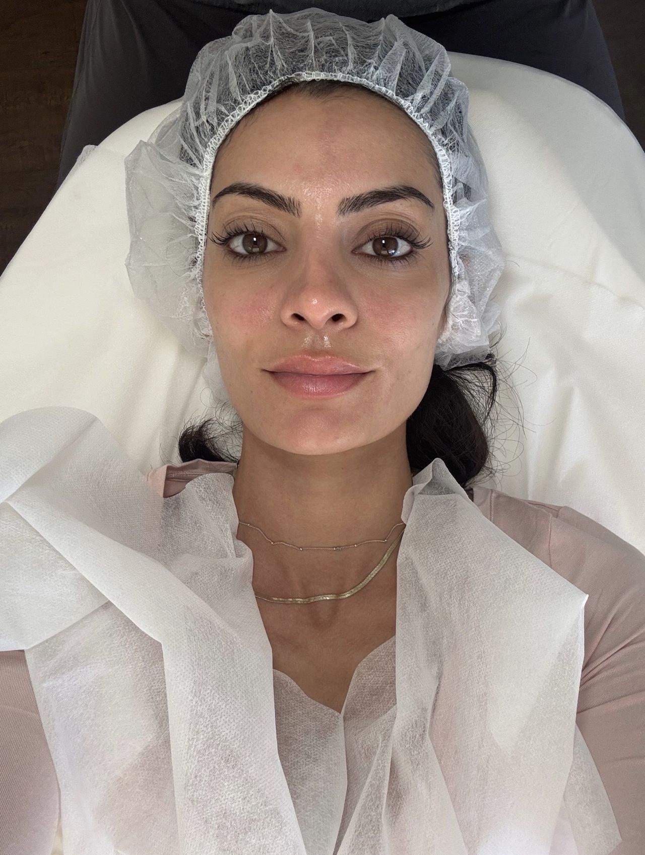 a woman with dark hair and dark eyes laying down with a hair net