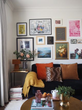 Homesense x Lisa Dawson living room with gallery wall framed wall art decor above black sofa with assortment of cushions