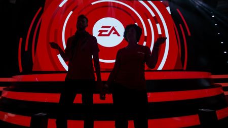 The silhouette of attendees are seen dancing in front of the Electronic Arts Inc. (EA) logo displayed on a screen during the company's EA Play event ahead of the E3 Electronic Entertainment Expo in Los Angeles, California, U.S., on Saturday, June 10, 2017. EA revealed two new titles along with the annual iterations of the company's sports games, as well as unveiling the highly anticipated "Star Wars: Battlefront II" open-world multiplayer gameplay. Photographer: Patrick T. Fallon/Bloomberg via Getty Images