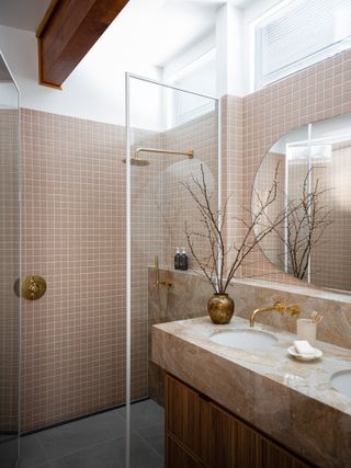 shower with pink tiles, marble countertop, glass shower doors