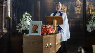 Vicar Billy Mayhew conducting Paul Foreman's funeral service. He is standing behind Paul's coffin with a picture of him on top.