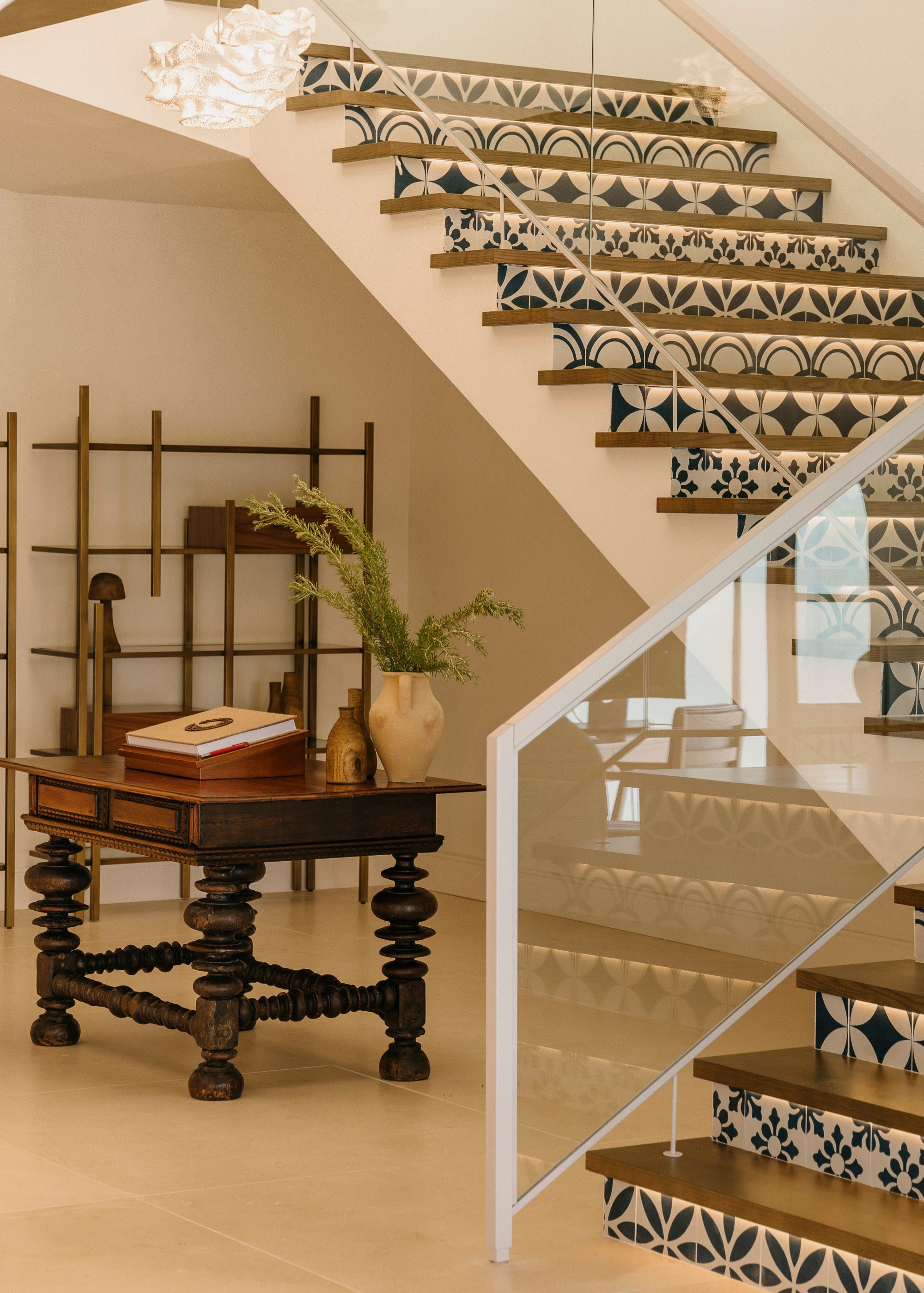 Staircases with traditional tiles and glass railings. There are also wooden accents around the space