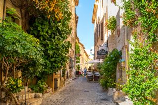 Cafes, shops and art galleries line the narrow cobblestone roads in the medieval hilltop village of St Paul de Vance on the French Riviera.